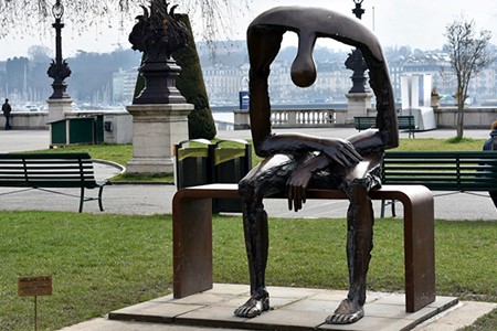 Feather Wing Counseling - Bronze sculpture of an abstract figure sitting on a bench, embodying grief.